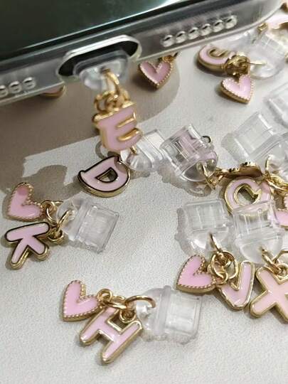 Tapón antipolvo de letra de dibujos animados rosa 2 en 1, 26 piezas de colgante de letra de aleación, tapón antipolvo de letra de corazón rosa y negro, compatible con el tapón antipolvo de interfaz tipo C