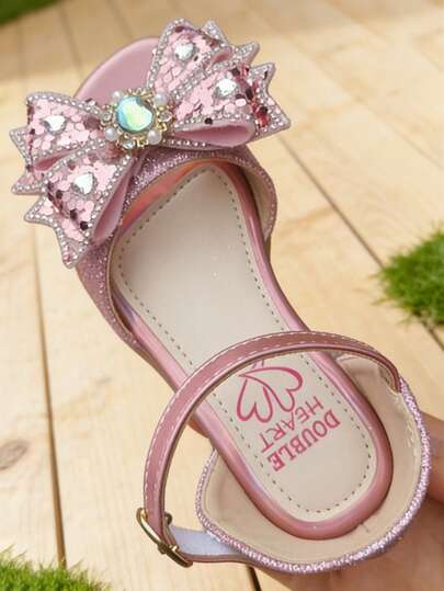 1 đôi sandal nơ lấp lấp lánh cho bé gái, thiết kế hở mũi, gót thấp, quai dễ mang, phù hợp cho tiệc tùng, sinh nhật và các dịp trang trọng.