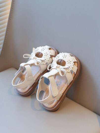 2026新款女童凉鞋，米色和粉色镂空设计，带蝴蝶结，可爱迷人，方便穿脱的魔术贴搭扣