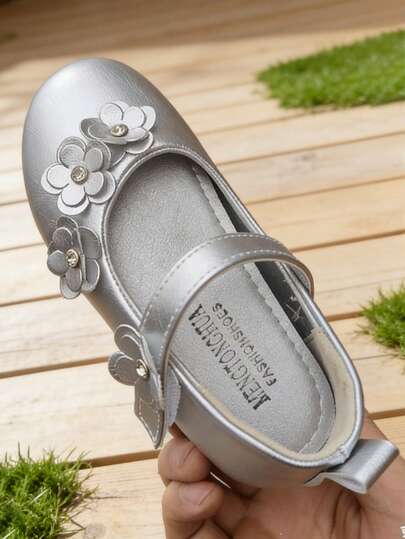 一双女童玛丽珍鞋，饰有花朵图案，鞋底柔软，配有魔术贴搭扣和舒适内衬，适合日常穿着和派对场合。