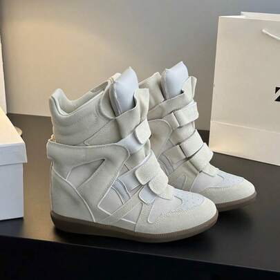 Novos tênis femininos 2026 com reforço oculto no calcanhar – Tênis de salto plataforma em camurça preta de alta qualidade, design retrô street style com biqueira de couro, sola leve e confortável, cores coordenadas, modelo baixo e casual, ideal para o dia a dia, looks street style e produções elegantes.