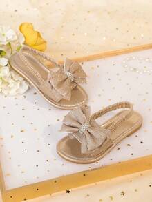 1 đôi sandal đế bằng màu vàng kim cỡ lớn dành cho bé gái, chất liệu PU mềm mại, bóng bẩy, trang trí nơ lớn, quai đeo mắt cá chân co giãn, mũi tròn, đế chống trượt thoải mái, kiểu sandal La Mã thời trang, thanh lịch, dễ thương phù hợp cho bé gái từ 3-15 tuổi, dùng hàng ngày, dự tiệc, du lịch, mùa xuân/hè 2026. - Hoa hồng vàng - Xem 5