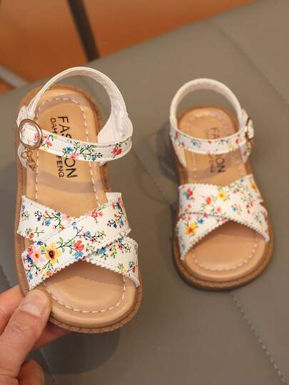 1 đôi dép xăng đan đế bằng hở mũi, quai chéo, chống trượt, in họa tiết hoa cho bé gái, kiểu dáng ngọt ngào, thích hợp cho bé mặc hàng ngày vào mùa hè.