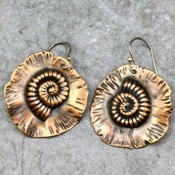 Brincos de cobre esculpidos à mão em formato de concha de náutilo, perfeitos para a praia.