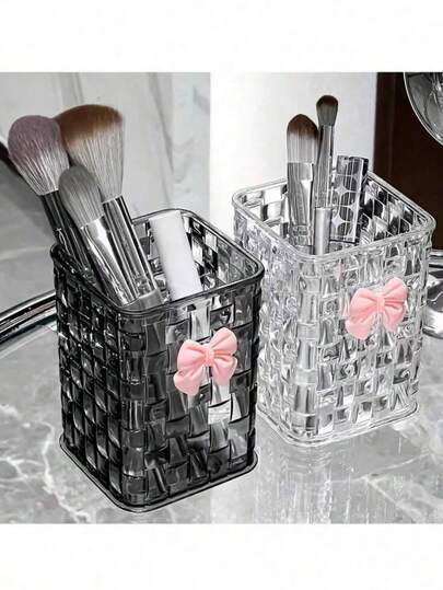 这款透明塑料桌面收纳盒采用编织纹理设计，配有粉色蝴蝶结装饰、笔筒和储物盒。黑白两色可选。它是一款多功能桌面收纳盒，非常适合存放学习用品、办公用品、宿舍用品、化妆品、护肤品和桌面必备物品。它也是送给女性的绝佳礼物之选，笔筒和储物盒尤其适合存放学习用品。办公桌配件 桌面摆件 办公用品 办公装饰 办公配件