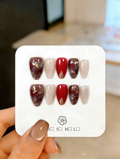 10片手工制作的短款杏仁形假指甲，采用不规则金箔片、弧形金箔片和红棕色琥珀渐变色设计。这些精美的假指甲可重复使用，易于佩戴和卸除，是优雅的美甲装饰。适合女孩和女士日常佩戴，也适用于派对、婚礼和节日美甲。套装包含美甲工具，例如果冻胶和指甲锉。