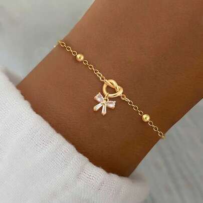 1 chiếc vòng tay thời trang mới, kiểu dáng nơ trái tim đính pha lê nhân tạo nhiều màu sắc, chất liệu thép không gỉ mạ vàng, dành cho nữ.