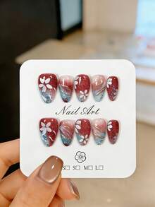 10片手工制作的短款杏仁形按压式假指甲，多处镶嵌银蓝色闪粉和碎钻，饰以金色线条、手绘白色五瓣花图案和酒红色渐变效果。这些可爱漂亮的假指甲可重复使用，易于佩戴和卸除，是优雅的美甲装饰。适合女孩和女士日常佩戴，也适用于派对、婚礼和节日美甲。套装包含美甲工具，如果冻胶和指甲锉。 - 紅色 - 查看 13