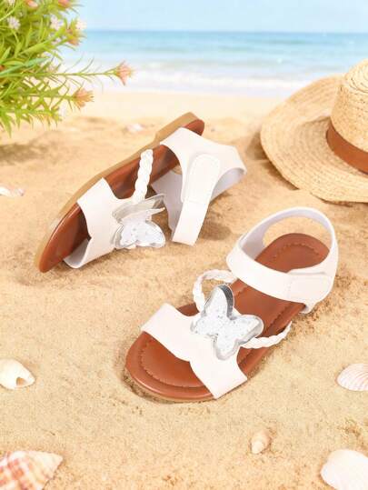 欧码 26-36 女童白色基础款魔术贴凉鞋，经典亮面蝴蝶装饰，棕色防滑鞋底，清新简约风格，适合日常休闲穿着、社区散步和暑假出行。