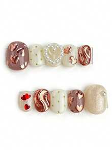 这款美甲套装包含10片指甲油，名为“巧克力心形绯红亮片”。它巧妙地融合了柔和的淡紫色和乳白色，玫瑰金心形和珍珠细节在柔和的底色上熠熠生辉，宛如一颗心在金色沙滩上翩翩起舞。红色心形和波浪纹理的点缀更添一丝俏皮奢华，营造出梦幻般的怀旧氛围。 - 彩色 - 查看 1