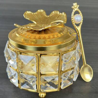 Hũ đựng đường tròn hai lớp, khung đính đá pha lê lấp lánh, nắp hình lá bạch quả 3D và điểm nhấn là vương miện ngọc trai, kèm thìa trang trí. Hộp đựng đường bằng thủy tinh mạ vàng sang trọng, thích hợp cho quầy cà phê, quầy bar, nhà bếp và trang trí nhà cửa.