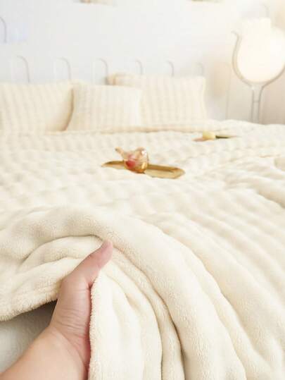 1条乳白色泡泡绒毯，单层卷边设计，亲肤柔软舒适，适用于沙发、床、空调房，可机洗，四季皆宜，适合卧室和客房使用。