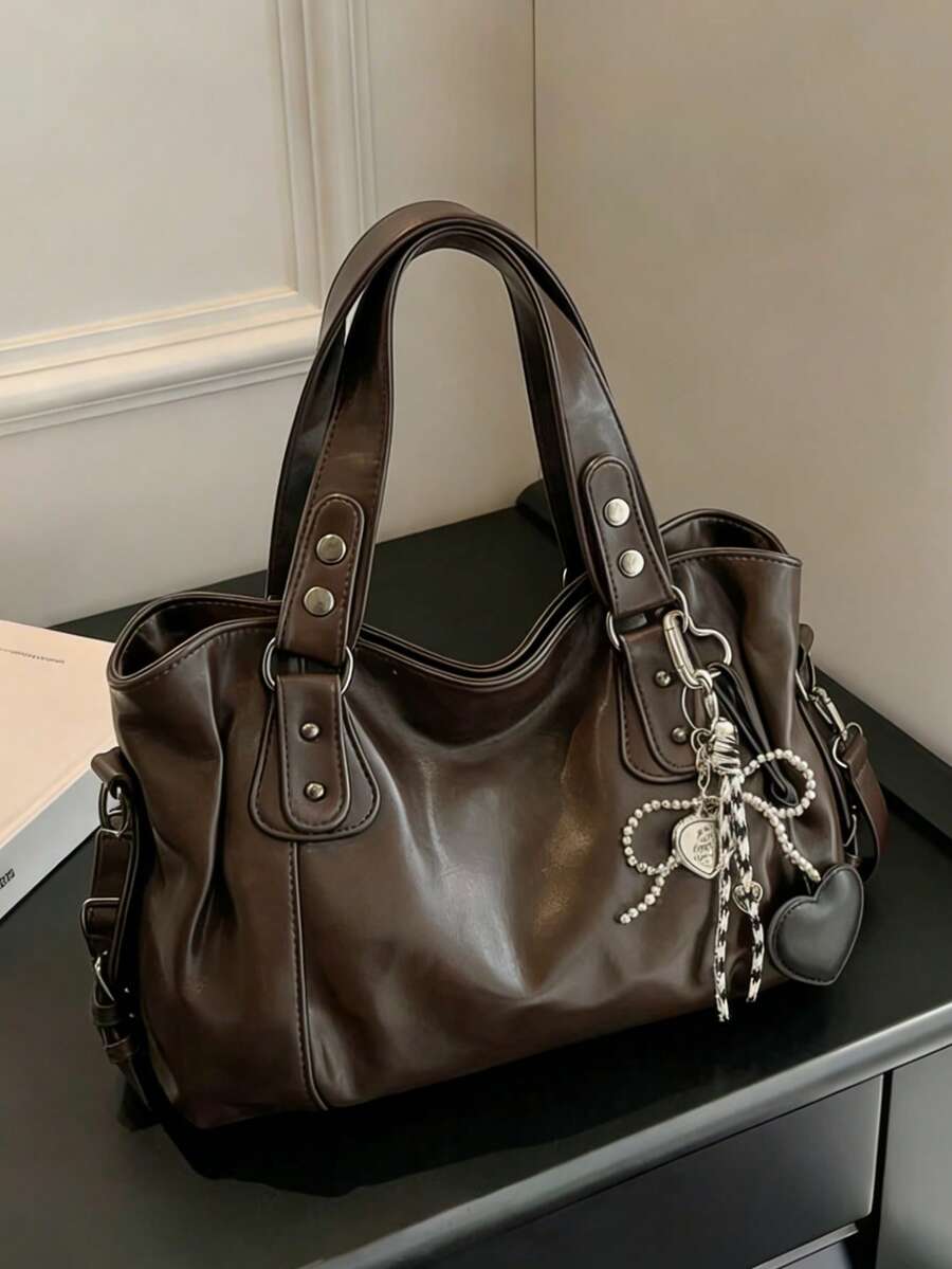 这款大容量女士手提包采用光泽感十足的咖啡色PU材质，饰有黑色心形吊坠，配有金属拉链、双提手和可调节肩带。可单肩背、手提或斜挎。适合女士外出、购物、户外旅行和日常通勤。 - 咖啡 - 查看 1