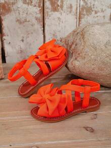 1 Paar orangefarbene Mädchen Flache Strand Sandalen, einfarbiger Stoff mit Schleifen Dekor, elastischer Kreuz-Rückenriemen Einteiliges Design, runde Zehenpartie, rutschfeste und strapazierfähige TPR Sohle, modische & niedliche römische Sandalen geeignet für 3-15 Jährige, Alltag, Party, Strand, Neu für den Sommer - Orange - Übersicht 1