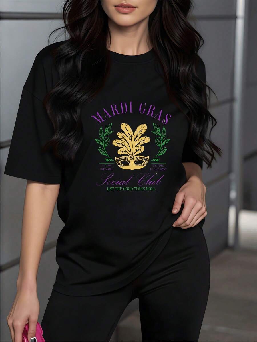 Máscara dorada rodeada de hojas verdes que simbolizan alegría y celebración típica del carnaval transmitiendo energía festiva y elegancia camiseta de mujer casual moderna suave 220g ideal para evento urbano o reunión social - Negro - Ver 1