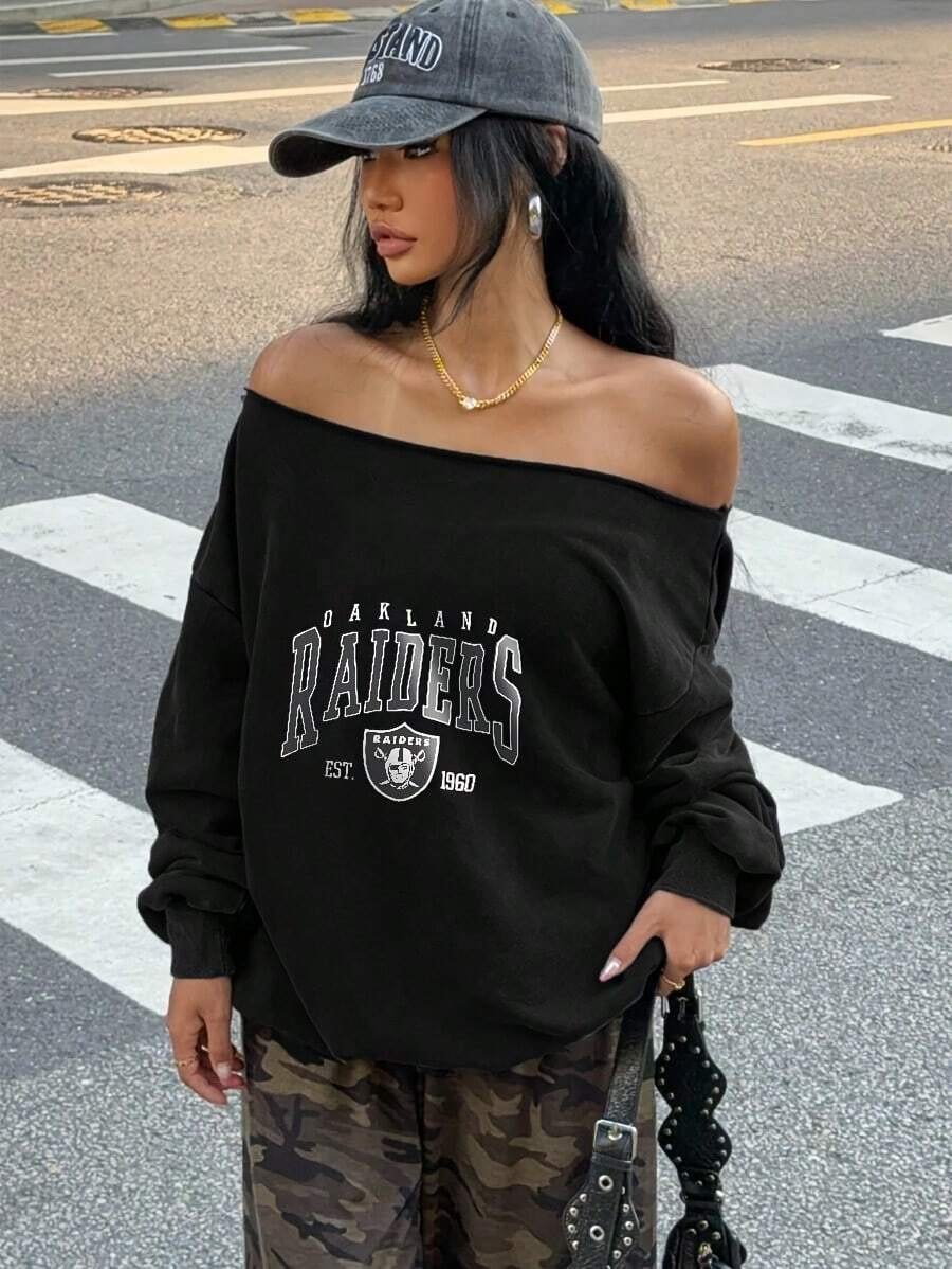 Women's Street Style Portrait Inspired Pullover Sweatshirt, Off-The-Shoulder Oversized Black Top With Distressed Grey White Varsity "OAKLAND " Graphics, Shield Logo & EST. 1960 Details, Raw Edge Neckline, Matched With High Waisted Loose Dark Green Brown Camo Cargo Pants, Silver Thin Large Hoop Earrings, Gold Chain Pendant Necklace, Gold Ring, Nude Pink Nail Polish, Black Studded Strap Crossbody Bag, Perfect Urban Streetwear Outfit For Daily Wear - màu đen - Xem 1