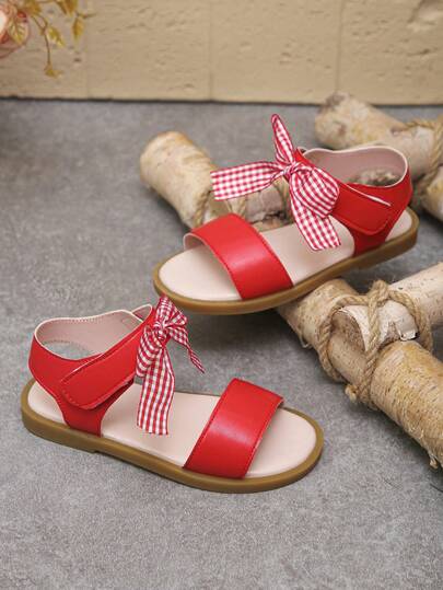 Un par de sandalias rojas para niñas en primavera y verano, de estilo sencillo y abierto, con un dulce estilo de lazos a cuadros rojos y blancos, adecuado para la escuela diaria, compras, fiestas de cumpleaños, viajes de vacaciones, fotos de vacaciones y otras ocasiones.
