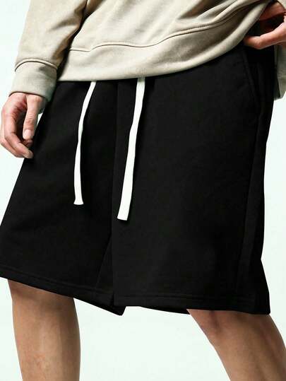 男士黑色纯色撞色抽绳休闲短裤，采用抗皱涤纶面料，机洗后无需熨烫即可穿着，适合通勤和短途出行；撞色抽绳腰带既实用（可调节松紧）又时尚，两侧隐藏式口袋可安全存放手机、钥匙和其他日常必需品。夏季