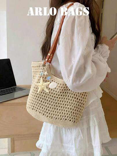 这款波西米亚风米色钩编拉菲草手提包饰有航海主题的海星和贝壳图案，并配有可调节皮革肩带。这款小巧的敞口肩背包非常适合夏季海滩旅行和女性日常使用。