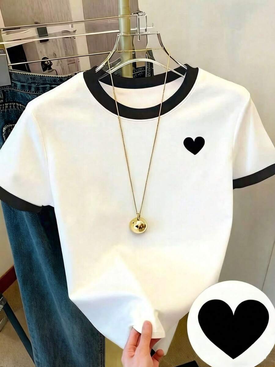 Camiseta de patchwork, diseño bicolor, con cuello y mangas negros, con pequeños patrones de corazones, confeccionada con tecnología de impresión digital. El diseño es colorido, llamativo y elegante, con cuello redondo y mangas cortas, lo que lo hace muy adecuado para el uso diario. Esta camiseta es holgada y cómoda, siguiendo las últimas . - Colores mixtos - Ver 1