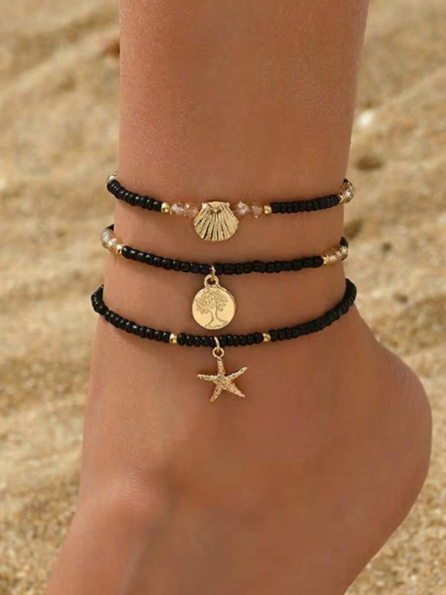 Tres piezas de tobilleras de mujer con temas de playa de verano que presentan colgantes con el árbol de la vida, estrella de mar y concha. Estas frescas y elegantes tobilleras están hechas con cuentas de arroz negro y cuerdas elásticas - Negro - Ver 1