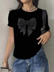 Gran lazo brillante formado por pequeñas piedras que simbolizan elegancia y confianza transmitiendo un aire de feminidad moderna y encanto sutil camiseta de mujer suave cómoda casual 220g - Negro - Ver 1