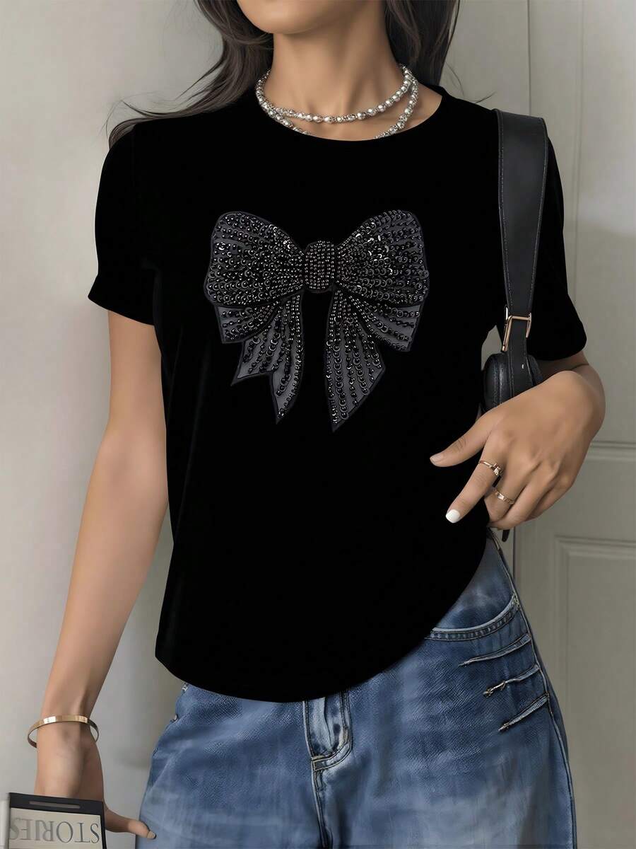 Gran lazo brillante formado por pequeñas piedras que simbolizan elegancia y confianza transmitiendo un aire de feminidad moderna y encanto sutil camiseta de mujer suave cómoda casual 220g - Negro - Ver 1