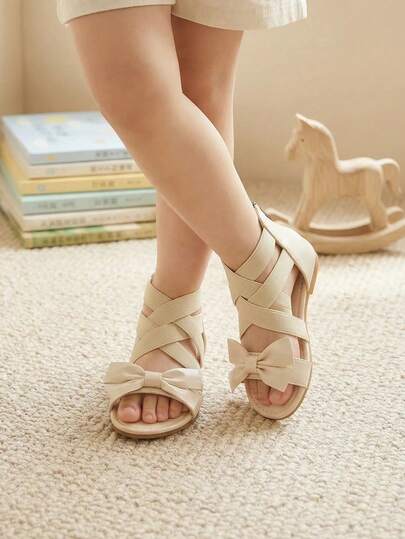 1 đôi dép xăng đan đế bằng mùa hè cho bé gái, màu be, quai chéo co giãn, kiểu La Mã có nơ trang trí, khóa kéo phía sau, thích hợp cho cắm trại ngoài trời, dự tiệc và phối cùng trang phục.