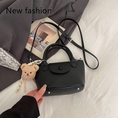 黑色荔枝纹皮革迷你手提包，优雅顶部提手斜挎包，配有可爱小熊挂饰和可拆卸肩带，非常适合日常休闲和购物场合。