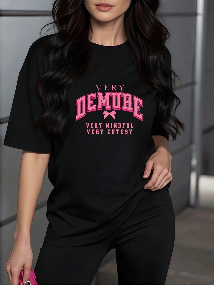 Texto inspirador que expresa una actitud confiada y dulce con letras grandes en rosa y una cinta en el centro que refleja una combinación de ternura y fuerza camiseta de mujer cómoda 220g para uso diario - Negro - Ver 1