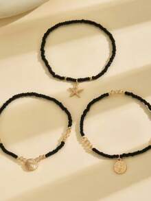 Tres piezas de tobilleras de mujer con temas de playa de verano que presentan colgantes con el árbol de la vida, estrella de mar y concha. Estas frescas y elegantes tobilleras están hechas con cuentas de arroz negro y cuerdas elásticas - Negro - Ver 5