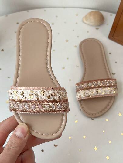 Một đôi sandal mùa hè cho bé gái với hạt cườm và đá lấp lánh nhiều màu sắc, kiểu dáng mùa hè mới năm 2026 với các hạt cườm, kim sa và đá lấp lánh được trang trí, có bề mặt mềm mại, phối màu khối, thiết kế hở mũi đế bằng thoải mái, kiểu dáng nhẹ nhàng, phù hợp cho cả kỳ nghỉ và sử dụng hàng ngày.