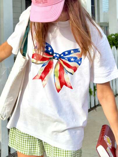 Watercolor American Flag Bow Graphic Round Neck T-Shirt - Viral Cute Aesthetic Street Style Essential | Soft Watercolor American Flag Bow Design, Easily Showcase Patriotic Feminine Style | Must-Have For July 4th, Summer Holidays And Everyday Wear | White Cotton Blend T-Shirt Blending National Pride And Elegant Charm