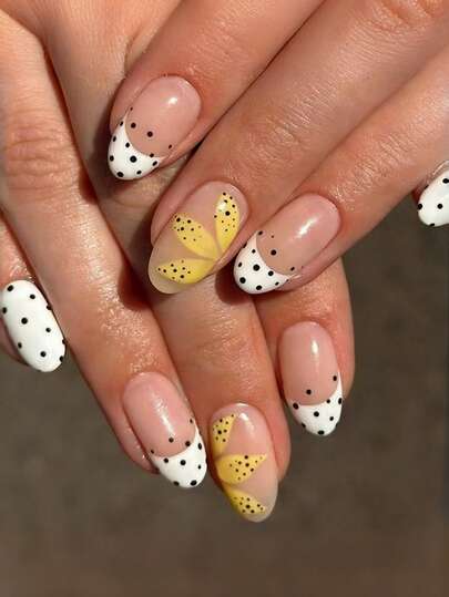 24片装黄色花朵波点美甲套装，椭圆形，可爱活泼的Y2K风格。裸色底色搭配黄色花朵图案、黑色波点和法式弧形边缘设计。法式假指甲，波点圆形图案假指甲，亚克力假指甲。适合女性约会、聚会、派对、工作等各种场合。