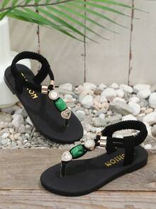 1双黑色女童平底人字拖，纯色柔软编织面料，交叉绑带设计，饰以闪亮水钻和绿色玛瑙，圆头柔软防滑一脚蹬设计，时尚可爱波西米亚风沙滩凉鞋，适合日常休闲、海滩、校园、舞蹈、春夏等场合。 - 黑色 - 查看 4