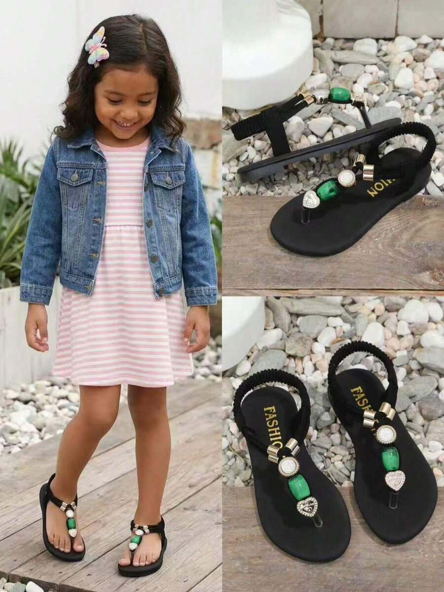 1双黑色女童平底人字拖，纯色柔软编织面料，交叉绑带设计，饰以闪亮水钻和绿色玛瑙，圆头柔软防滑一脚蹬设计，时尚可爱波西米亚风沙滩凉鞋，适合日常休闲、海滩、校园、舞蹈、春夏等场合。 - 黑色 - 查看 1