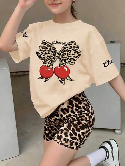 Bộ 2 món gồm áo tay ngắn và quần short in hình báo đốm, nơ và quả anh đào hoạt hình, thích hợp cho bé gái mùa hè.