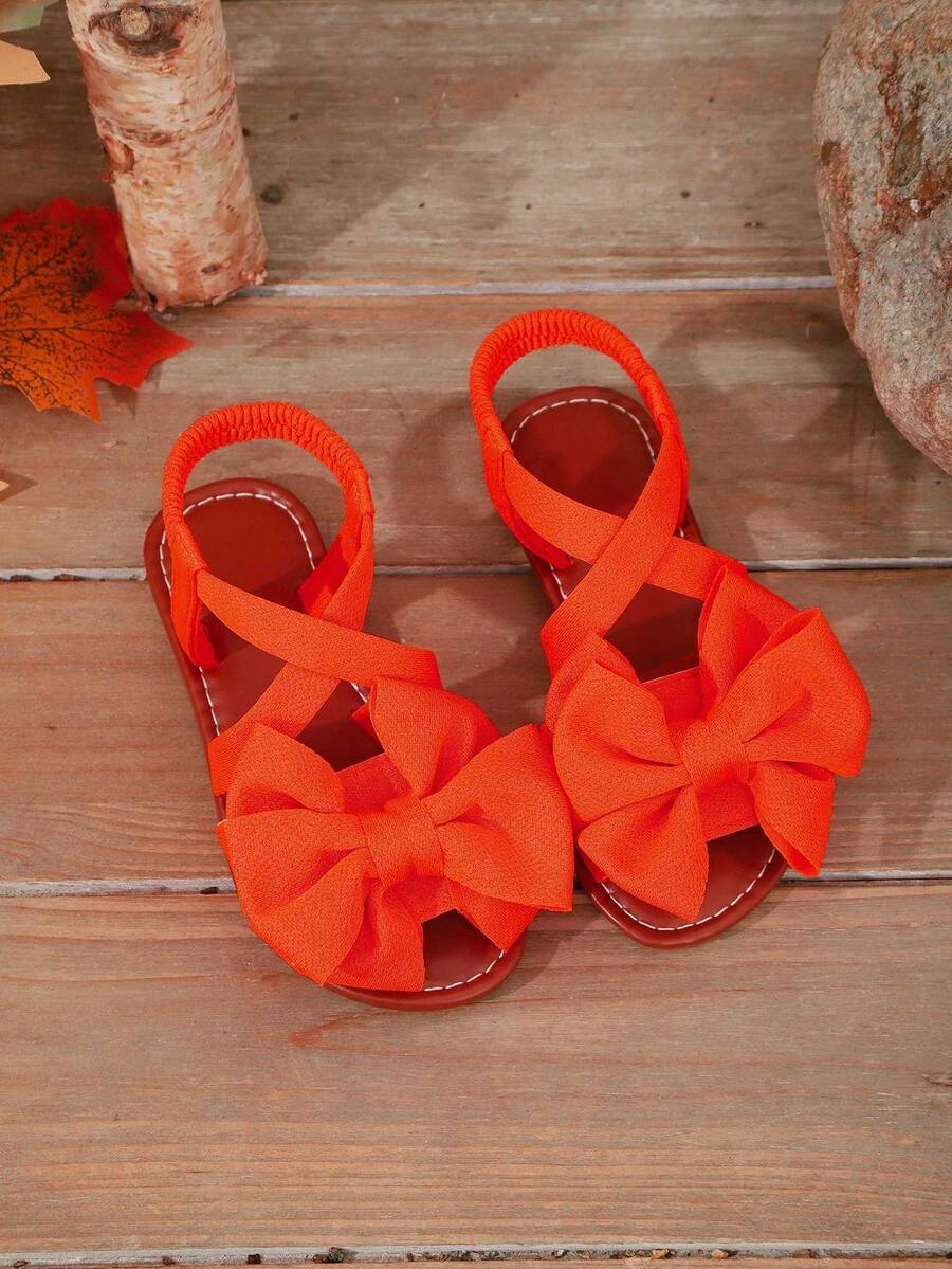 1 đôi dép xăng đan đế bằng màu cam cho bé gái, chất liệu vải mềm mại, quai chéo màu trơn với nơ trang trí, mũi tròn cổ điển, hở ngón, mềm mại, chống trơn trượt, kiểu dáng công chúa dễ thương, dép đi biển thời trang cho hàng ngày, đi chơi, đi nghỉ mát, đi học, mẫu mới mùa xuân/hè. - trái cam - Xem 1