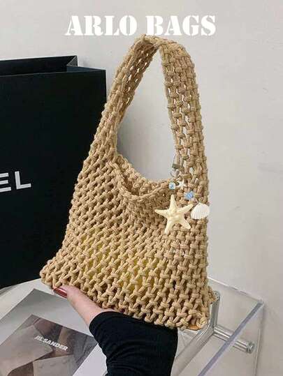 Detta är en virkad, genombruten tygväska med sjöstjärnespänne. Den lätta nätväven och de triangulära handtagen gör den perfekt för strandresor och avslappnade utflykter.