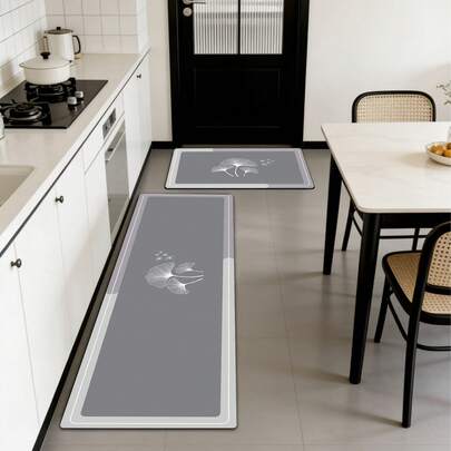1 tấm thảm bếp silicon cao cấp hiện đại, màu chủ đạo là xám trang nhã, với viền chuyển màu hai tông xám nhạt và trắng, được trang trí bằng họa tiết lá bạch quả trắng tinh tế, mang đến phong cách tối giản, tươi mới và sang trọng. Thảm bếp chống mỏi chân với bề mặt vải, lớp giữa thấm hút bằng mút xốp và đế cao su chống trượt.