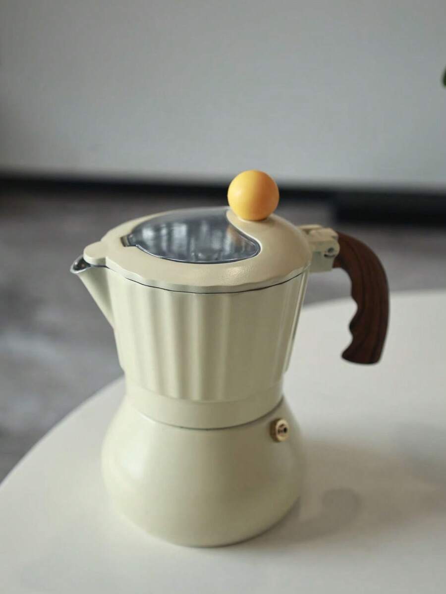 Ấm pha cà phê Moka thân trắng sữa, mái vòm vàng, nắp trong suốt, kiểu dáng Ý, nhỏ gọn và dễ thương, phù hợp với bếp ga hoặc bếp từ, rất thích hợp làm quà tặng.
