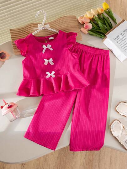 女童无袖上衣和裤子套装，荷叶边袖口、荷叶边下摆和蝴蝶结装饰，休闲可爱，是送给女孩的礼物。