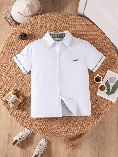 Áo sơ mi trắng tay ngắn có túi, kiểu dáng cổ điển thường ngày dành cho bé trai, thích hợp cho các dịp trang trọng, đi học, dự tiệc, biểu diễn.