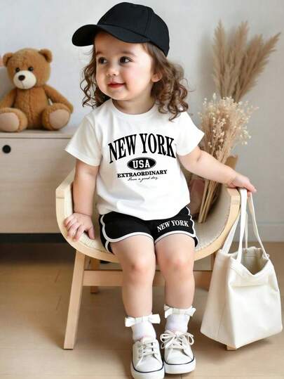 Bộ đồ thường ngày cho bé gái: áo thun ngắn tay in chữ và quần short.