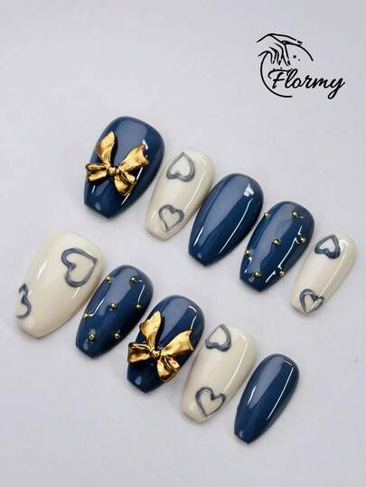 Bộ 10 móng giả thủ công kiểu cổ điển hình quan tài, điểm nhấn là nơ vàng 3D đính đá và hình trái tim 3D bằng nhựa. Có hai màu trắng ngà và xanh hoàng gia, những móng giả này lấp lánh với hiệu ứng đổi màu tùy thuộc vào góc nhìn, được tô điểm thêm bằng ngọc trai vàng. Dễ thương và ngọt ngào, chúng tôn lên vẻ thanh lịch và làm nổi bật đôi tay của bạn. Bền lâu và đã được dán sẵn gel và lớp nền, chúng hoàn hảo cho những buổi đi chơi mùa xuân và mùa hè, những buổi hẹn hò và sử dụng hàng ngày.