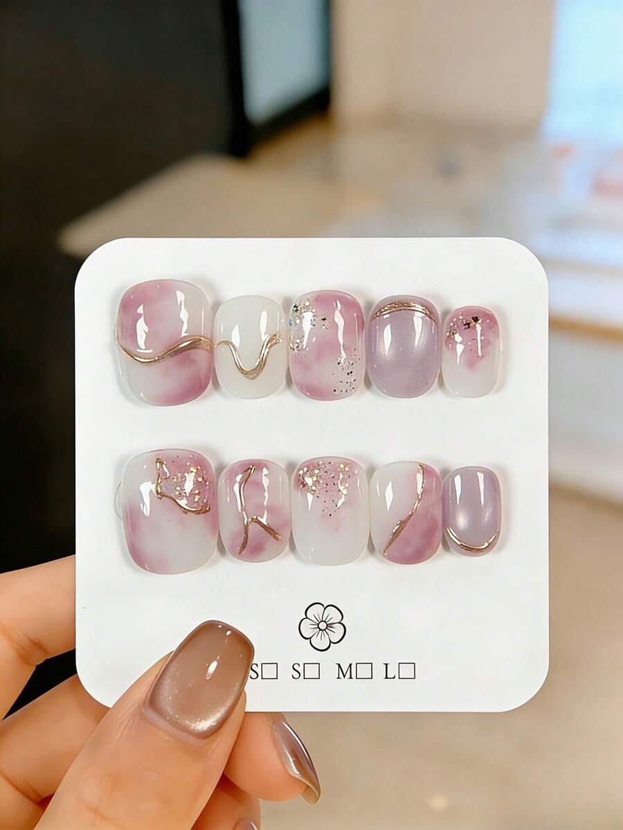 10片手工制作的短款按压式假指甲（可佩戴），既是美甲用品又是装饰品，饰有玫瑰金细线和粉紫色渐变效果。这些精美的假指甲可重复使用，易于快速卸除，是优雅的美甲装饰。适合女孩和女士日常佩戴，也适合派对、婚礼和节日美甲。套装包含美甲用品，例如果冻胶和指甲锉。 - 紫丁香色 - 查看 1