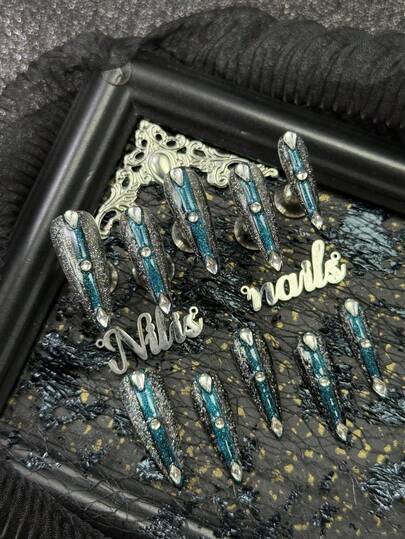 Bộ móng giả acrylic 10 món, màu xanh dương nhạt, kẻ viền đen ở giữa, mắt mèo màu xanh dương nhạt, kim tuyến laser, kim cương 3D hình giọt nước lớn, kim cương lớn và nhiều kim cương nhỏ trong suốt cùng các phụ kiện làm móng khác.