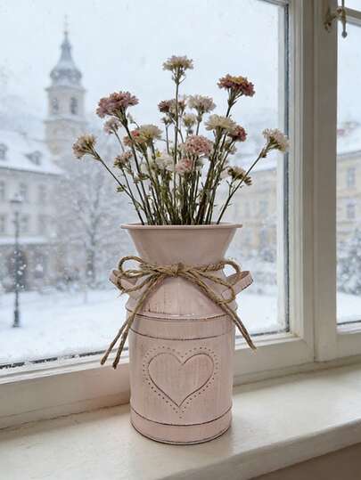 Soft Pink Distressed Iron Vase. The Soft Pink Base Color Echoes The Heart Element, Giving The Vase A Gentle, Healing Feel, As If It Were A Warm Little Item Found At A Vintage Market. It Can Be Placed Alone, Or With A Rose, Daisy Or Other Floral Bouquet To Create A Fresh And Cozy Focal Point In The Space. Filled With Dried Flowers, It Can Create A Tranquil, Vintage-Inspired Ambiance, Suitable For Various Warm And Welcoming Settings.