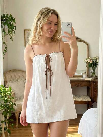 Women's French-Style Gentle Aesthetic Slip Dress: Features Contrasting Faux Leather Cord Ties, Delicate Ruffle Trim, And A Bold Contrasting Floral Print Design. Boasting A Loose A-Line Silhouette, It Is Crafted From Breathable, Skin-Friendly Fabric Ideal For Everyday Casual Wear. Machine Washable. A Standard-Fit Summer Garment Offering A Blend Of Comfort, Alluring Charm, And Minimalist Simplicity.