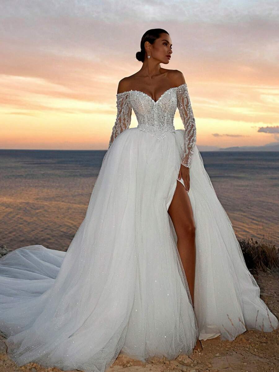 Elegant Off-Shoulder Long Sleeve A-Line Gown With Side Slit In Sheer Organza – Exquisite Floor-Length Dress Featuring A Dramatic Off-Shoulder Neckline And Flowing Long Sleeves That Frame The Arms Beautifully, Paired With A Leg-Revealing Slit For Modern Allure. The Lightweight Organza Fabric Creates A Graceful A-Line Silhouette That Moves Beautifully. Perfect For Halloween Formals, Thanksgiving Gatherings, And Charity Fundraisers, Its Timeless Design Complements Pearl Jewelry And Heels Beautifully At Anniversary Dinners, Boat Parties, And Graduation Formals. - White - View 1